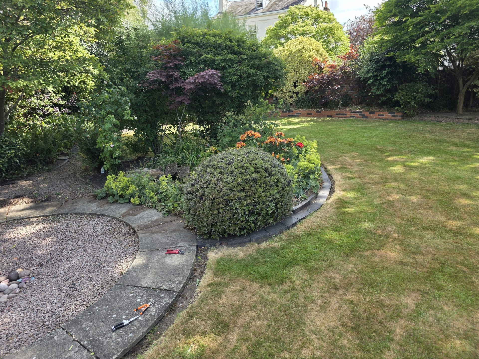 Garden maintenance Kidderminster – low shrubs, tidy borders, and shaded path.