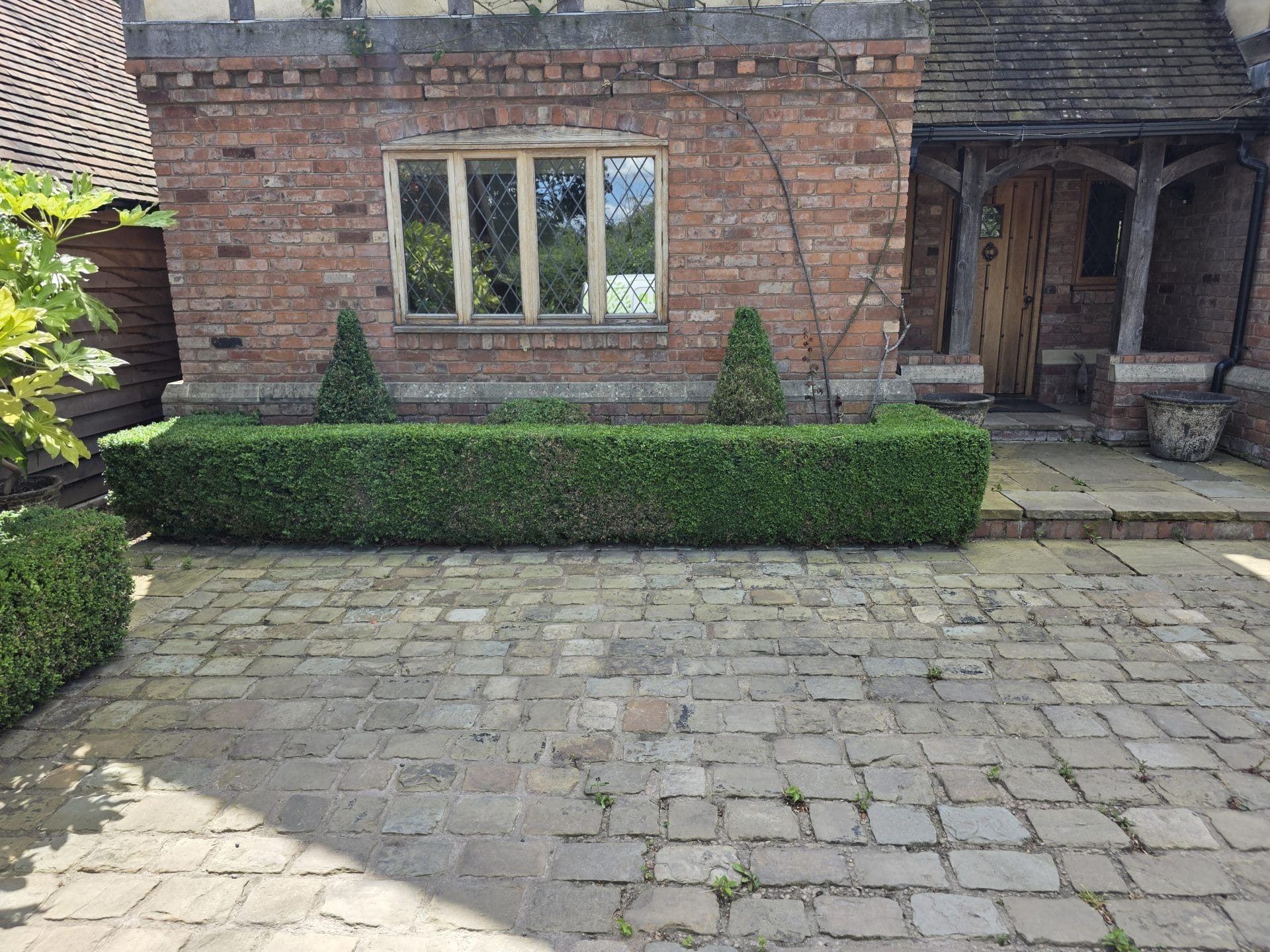 Garden maintenance Kidderminster – manicured shrubs and cobbled driveway.