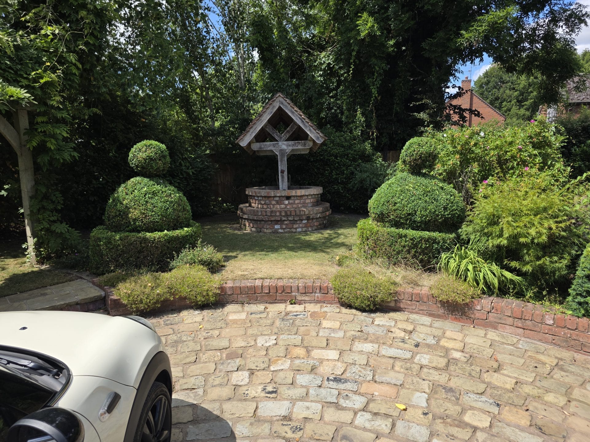 Garden maintenance Worcester featuring shaped topiary and driveway.
